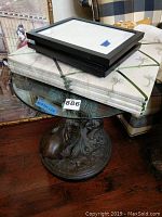 Round glass top table with elephant base, seen from above with the frames and memory boards stacked on top