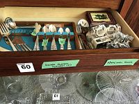 Drawer showing the full set of silver plated cutlery and some additional items in the drawer behind.