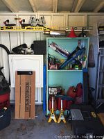 Teal metal shelving with funnels on top, Bosch blade packs and red gas cans on shelves