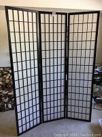 Front view of three-panel room divider showing black grid and white panels.