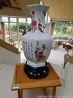 Handcrafted Menko vase displayed on wooden table with living room background