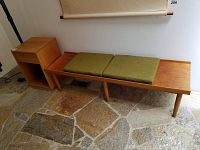 Bench and nightstand side by side on stone floor against wall