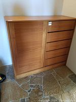 Front view of teak dresser showing left-side door and five right-side drawers