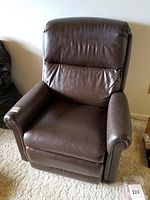 Front view of brown leather recliner chair with cushioned back and arms.