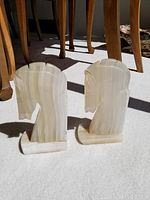 Pair of onyx horse head bookends on carpeted floor with wooden chair legs in background