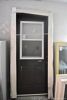 Full view of steel door with frame wrapped in protective white foam.