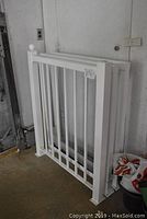 White deck railing with vertical spindles leaning against wall in garage.