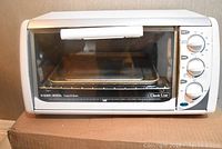 Front view of Black & Decker Classic Line toaster oven showing glass door, handle, and control knobs.