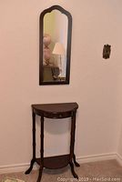 Demi lune table with drawer and mirror above on wall