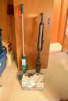 Full lot view showing the Bissell 3-in-1 vacuum on the right, rechargeable Swiffer on the left, and boxed Big Catch handheld vacuum in front.