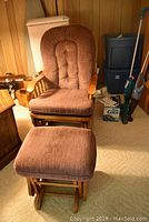 Full view of wood frame glider chair with brown fabric cushions and matching footstool