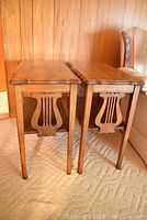 Pair of wood end tables side by side showing harp design on ends and straight legs.