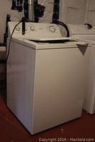 Full side and front view of white Hotpoint top-loading washing machine with control panel visible