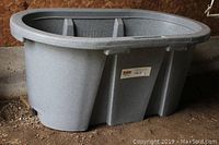 Side view of gray oval Polytuff by Behlen Country livestock trough with molded reinforcements and smooth rim.