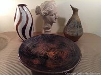 Lot overview showing large ceramic bowl, classical bust, and two pottery vases