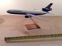 Full side view of the Canadian Airlines model plane on the stand with measuring tape showing length.
