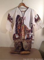 Full front view showing dress shirt with printed Indigenous chief image and moccasin boots placed beneath the shirt.