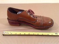 Side view of a brown leather shoe with laces, measuring about 11 inches long.