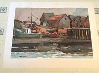 Full view of print depicting harbor scene with boats and buildings, mounted on white mat board with decorative corner accents