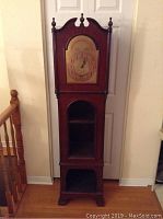 Full front view of the grandfather clock styled shelving unit showing its overall design and dimensions.