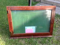 Front view of the large wooden display case showing glass door and green felt interior backing.