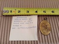Photo showing the Hindenburg Service Medal alongside a measuring tape indicating size of approx 1.5 x 2 inches, with a handwritten note describing medal awarded to WW1 veterans.