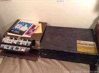 Two vintage sign making kits including a black Display Master box with yellow label and a wood-patterned box.