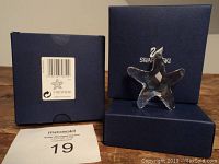 Starfish figurine inside original Swarovski blue box with lid on side and tag showing barcode and product info.