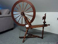 Front view of wooden spinning wheel showing overall shape and condition