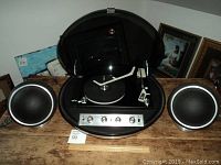 Front view of record player with dome open and two speakers
