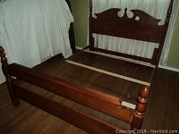 Full bed frame assembled on floor, side angle showing footboard and headboard