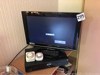 Sharp 19-inch LCD TV powered on showing input screen with a price tag on bezel.