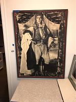 Framed black-and-white photo print of Rudolph Valentino in an elaborate costume, size around 32x42 inches, displayed on a wall.