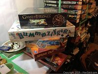 Stack of board games and puzzle, sealed and new in boxes.