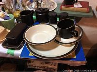 Side view of plates, bowls, cups and butter dish on table illustrating the design and condition of the Doverstone Staffordshire Heather dinnerware.