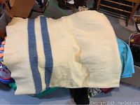 Cream wool blanket with two vertical blue stripes lying folded