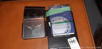 Black coin album with eagle design and accompanying blue and green Canada coin album, showing lot contents.