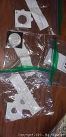 Overview of four coins in 2×2 flips and plastic baggies on wood surface.