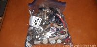 Photo shows a bag full of assorted wristwatches including leather and metal bands in various colors and styles piled together.