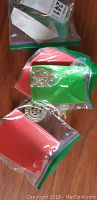 Badges and pins loosely packed in small clear plastic bags on wooden surface.