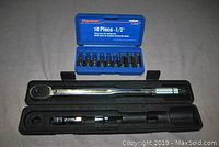 Westward 10-piece 1/2" drive hex bit socket set with sockets neatly arranged in a blue hard case, and socket wrench set including torque wrench and socket adaptors in black case.