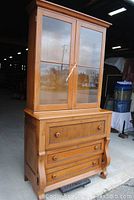 Full view of two-piece desk showing glass display cabinet atop lower drawer base