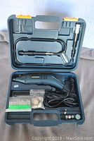 Open case showing Mastercraft rotary tool, flexible extension shaft, various grinding and cutting accessories, and power cord inside blue plastic case.
