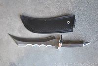 Gothic ceremonial blade with painted wood handle next to black leather sheath lying on concrete surface, blade length 10 inches, handle and blade total 16.5 inches.