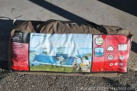 Packed Ventura family cabin tent in its brown fabric carrying case showing label with tent image and specifications.
