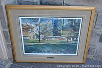 Framed limited edition graphic showing full artwork with frame and plaque, positioned against stone background