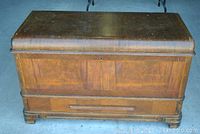 Front angled view of cherry wood chest showing top closed and wood grain detail.