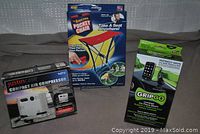Lot contents showing all three products in packaging: Justincase air compressor, GripGo phone mount, The Amazing Pocket Chair.