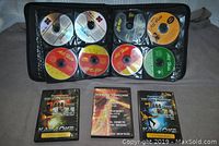 First photo showing a black zippered binder with 10 CDs in plastic sleeves, various colored karaoke CDs including some labeled 'All Hits' and others blank or generic