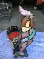 Overall view of the stained glass rooster lamp showing the colorful stained glass pieces and red comb from one angle.